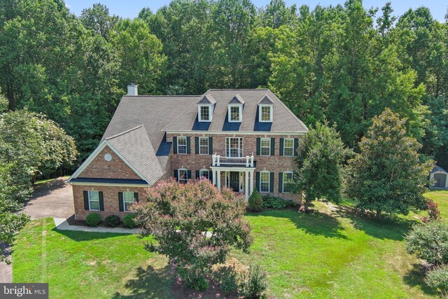 colonial inspired home featuring a front lawn