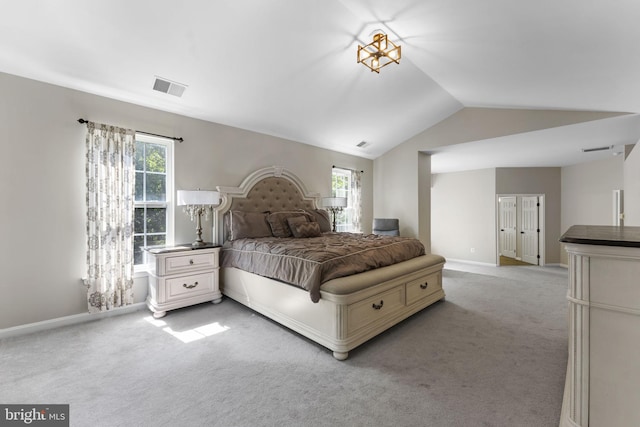 bedroom with multiple windows, vaulted ceiling, and light colored carpet