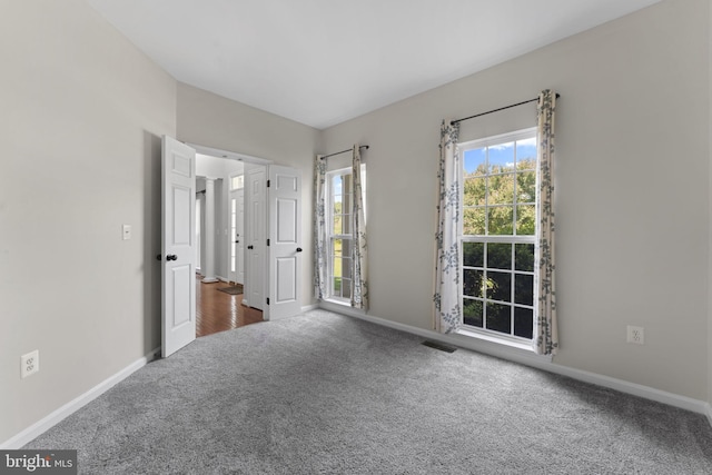 unfurnished bedroom featuring carpet, visible vents, and baseboards