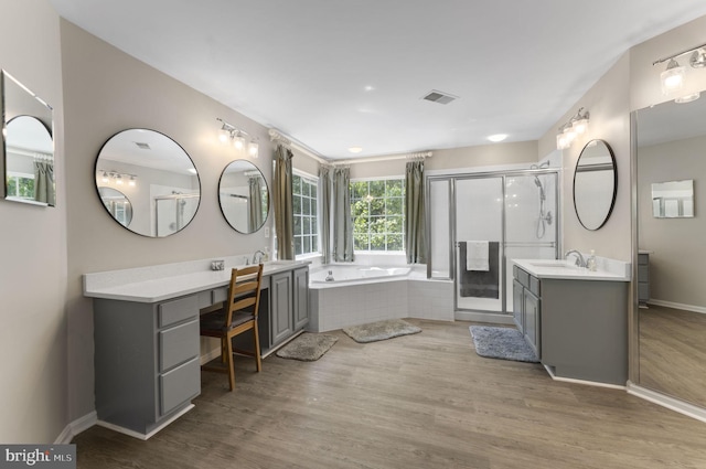 bathroom with wood finished floors, visible vents, vanity, a shower stall, and a bath