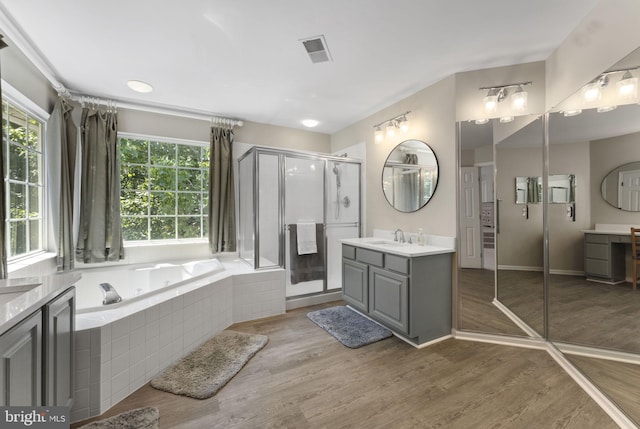 bathroom with a garden tub, visible vents, vanity, a shower stall, and wood finished floors