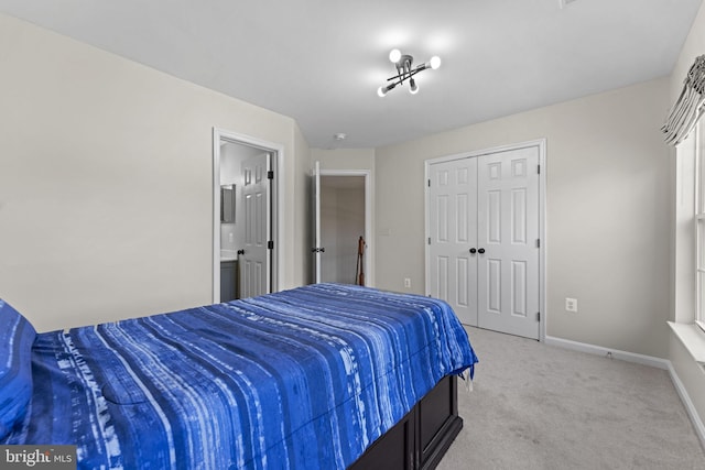 bedroom featuring a closet, light carpet, and baseboards