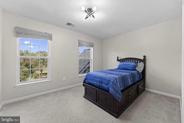 bedroom featuring visible vents, light carpet, and baseboards