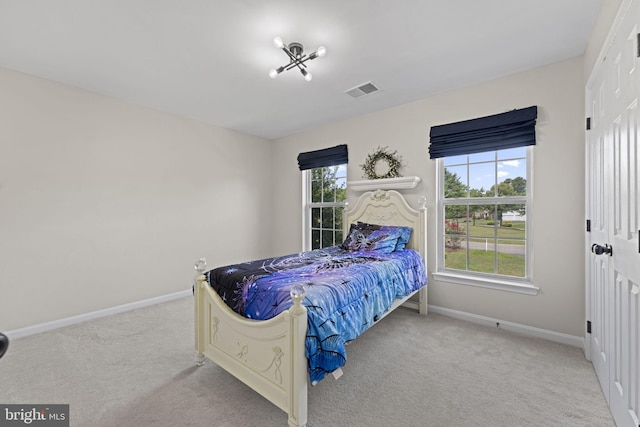 bedroom featuring light carpet, visible vents, and baseboards