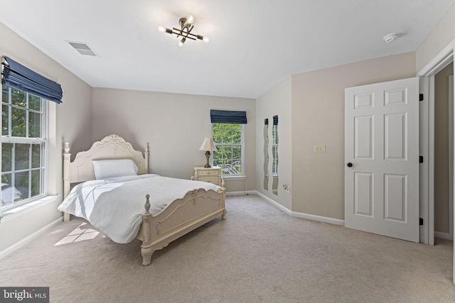 bedroom with visible vents, light carpet, and baseboards