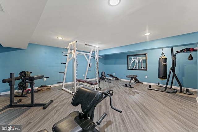 workout area with baseboards, wood finished floors, and recessed lighting