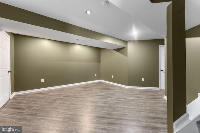 finished below grade area featuring light wood-style flooring, baseboards, and recessed lighting