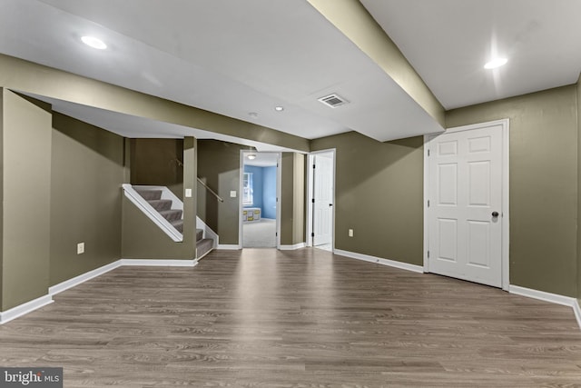 finished below grade area with recessed lighting, visible vents, wood finished floors, baseboards, and stairs