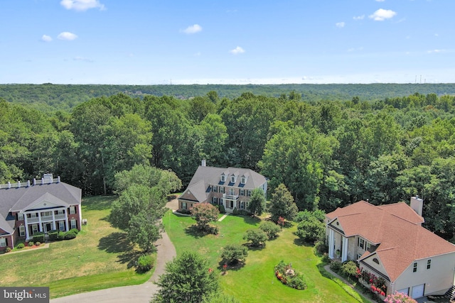 drone / aerial view with a wooded view