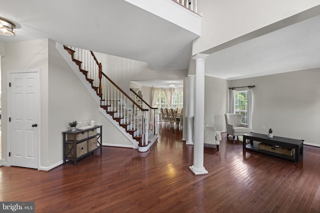 foyer entrance featuring stairway, dark wood finished floors, and decorative columns