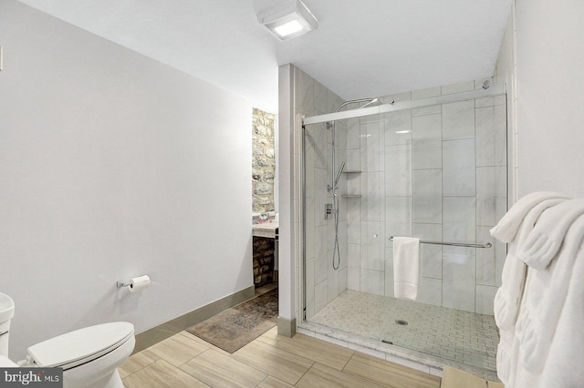 bathroom with toilet and an enclosed shower