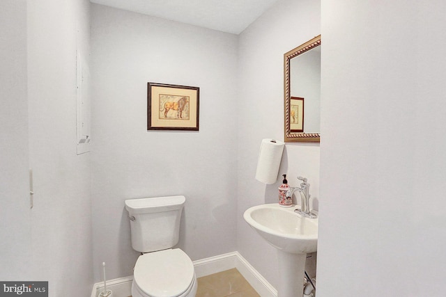 bathroom with toilet and tile patterned floors