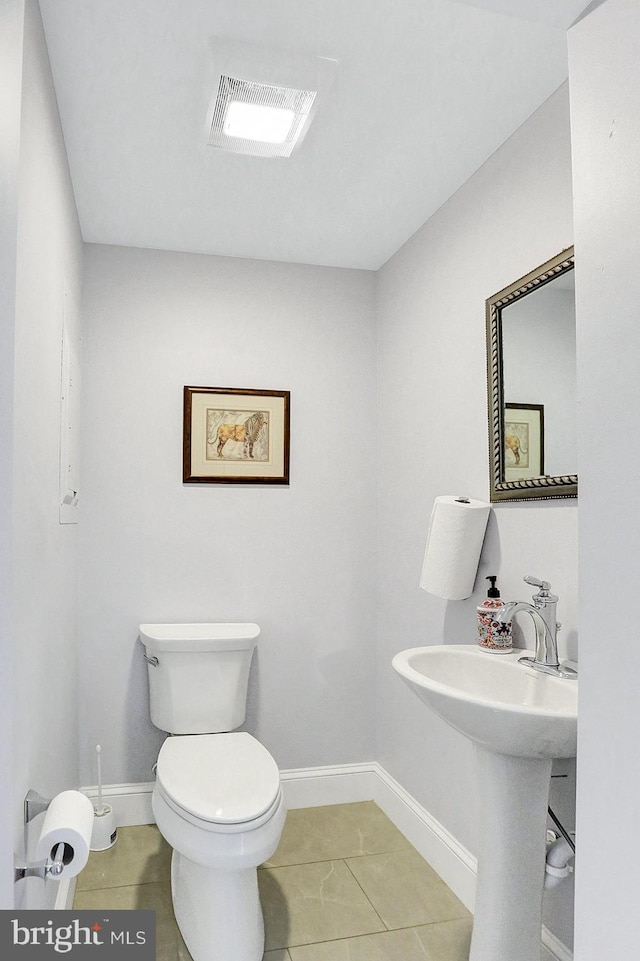 bathroom with sink, toilet, and tile patterned flooring