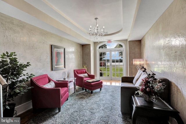 living room featuring a notable chandelier, carpet floors, and a tray ceiling