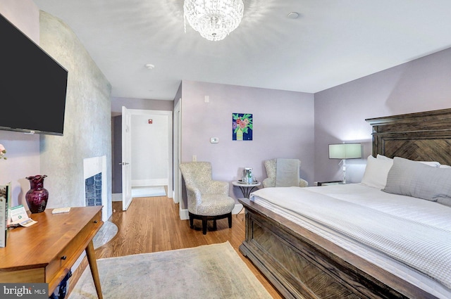 bedroom with a chandelier and light wood-type flooring