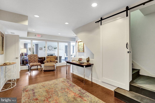 interior space with a barn door, dark wood-type flooring, and plenty of natural light