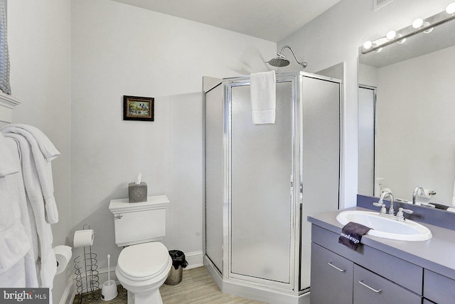 bathroom featuring vanity, toilet, and a shower with shower door