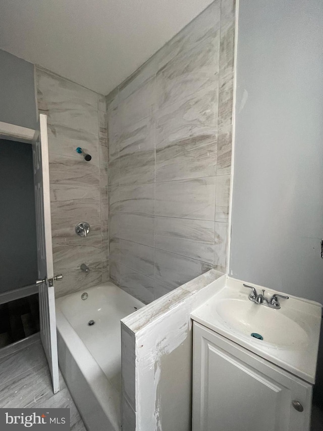 bathroom with vanity and tiled shower / bath