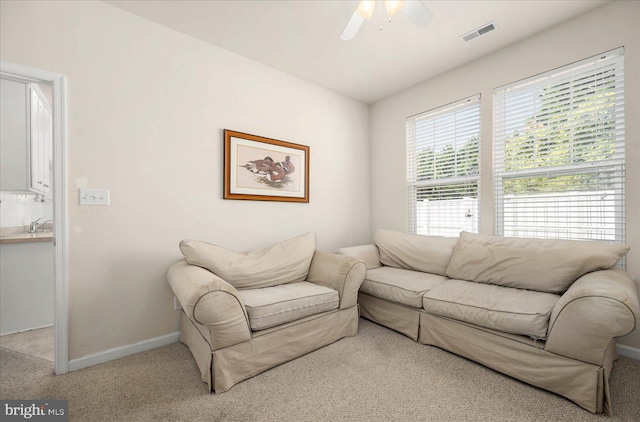 carpeted living room featuring ceiling fan