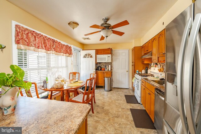 kitchen featuring light tile patterned floors, tasteful backsplash, stainless steel appliances, and ceiling fan