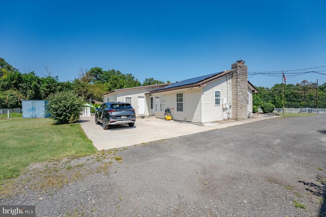 view of front of home featuring a front yard and solar panels