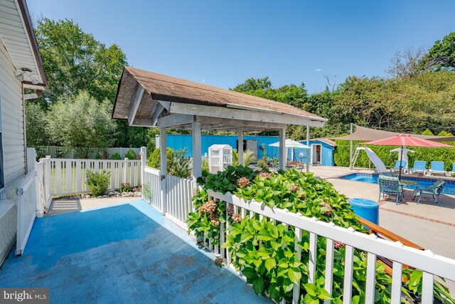 view of patio featuring an outbuilding and a fenced in pool