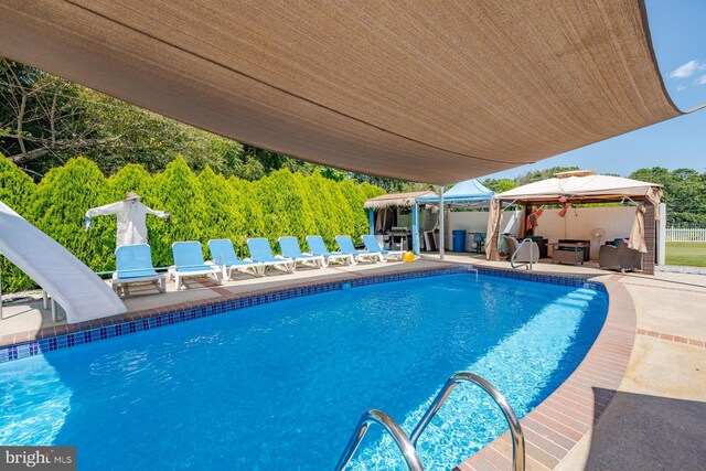 view of pool featuring a gazebo, a patio area, and a water slide