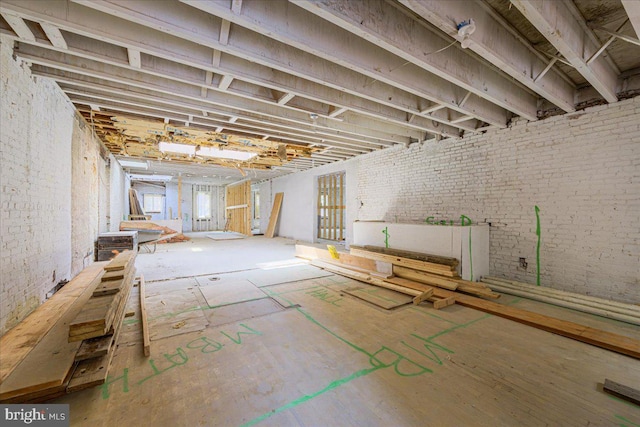 basement with plenty of natural light and brick wall