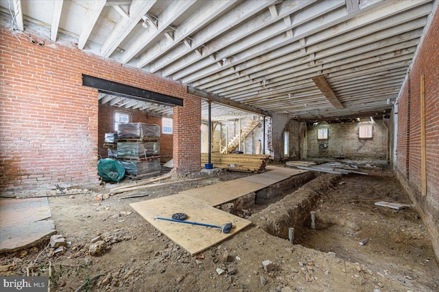 miscellaneous room featuring a healthy amount of sunlight and brick wall