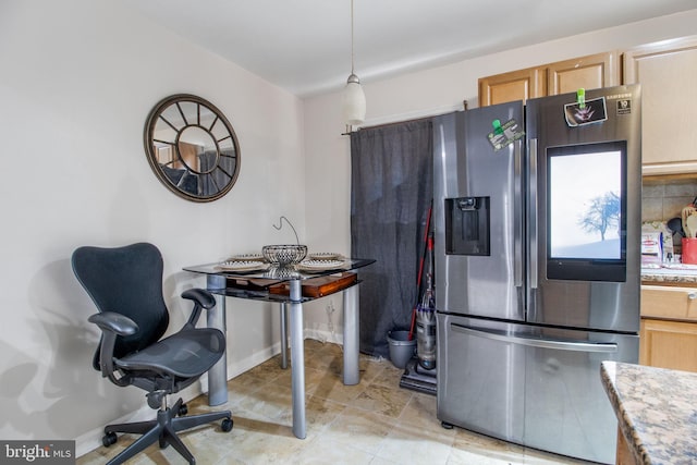 kitchen featuring hanging light fixtures, light brown cabinets, and stainless steel fridge