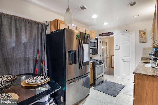 kitchen with light stone counters, pendant lighting, appliances with stainless steel finishes, and light tile patterned floors