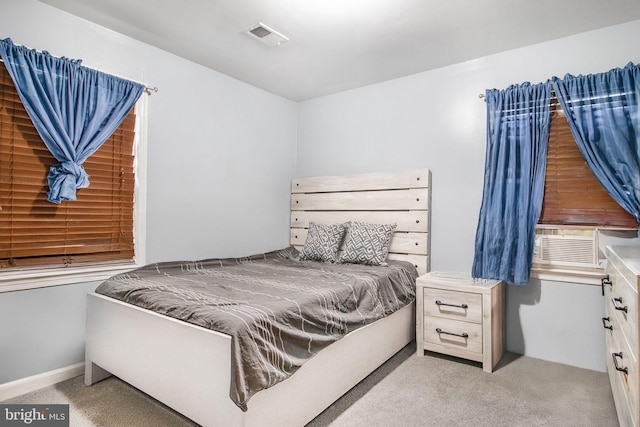 bedroom featuring light carpet, cooling unit, and visible vents