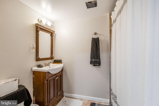 full bath featuring vanity and baseboards