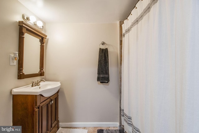 full bath featuring baseboards and vanity