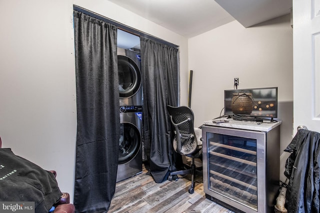 interior space featuring wine cooler, stacked washer / dryer, and wood finished floors