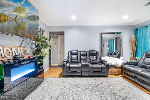 living room featuring visible vents, crown molding, baseboards, and wood finished floors