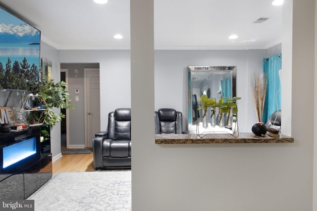 living room with ornamental molding and light hardwood / wood-style flooring