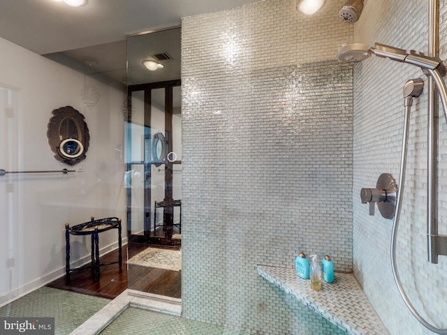 bathroom featuring tile patterned flooring and tiled shower