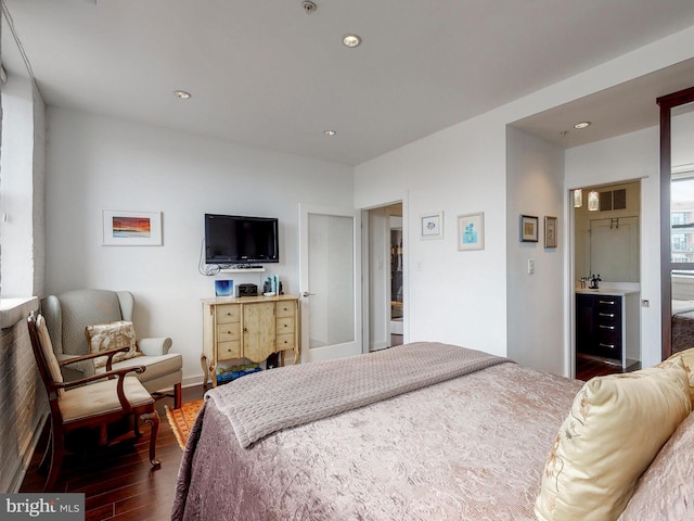 bedroom with dark hardwood / wood-style flooring and ensuite bathroom