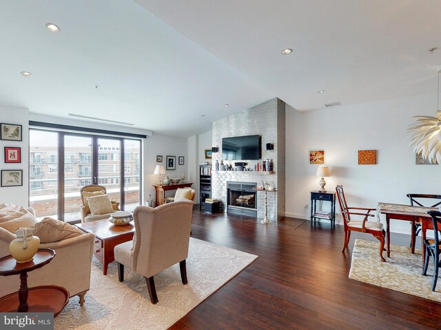 living room with lofted ceiling, a fireplace, and dark wood-type flooring