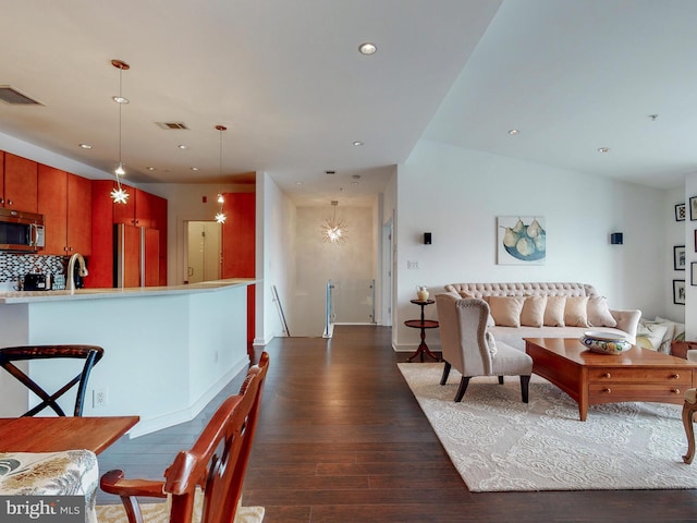 living room with dark hardwood / wood-style flooring, lofted ceiling, and sink