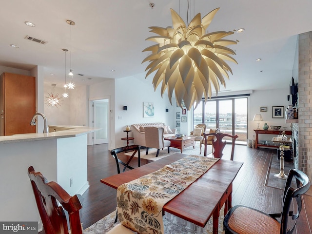 dining area featuring dark wood-type flooring and an inviting chandelier