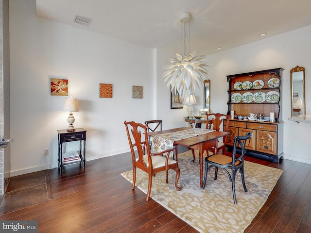 dining room featuring dark wood-type flooring, visible vents, and baseboards