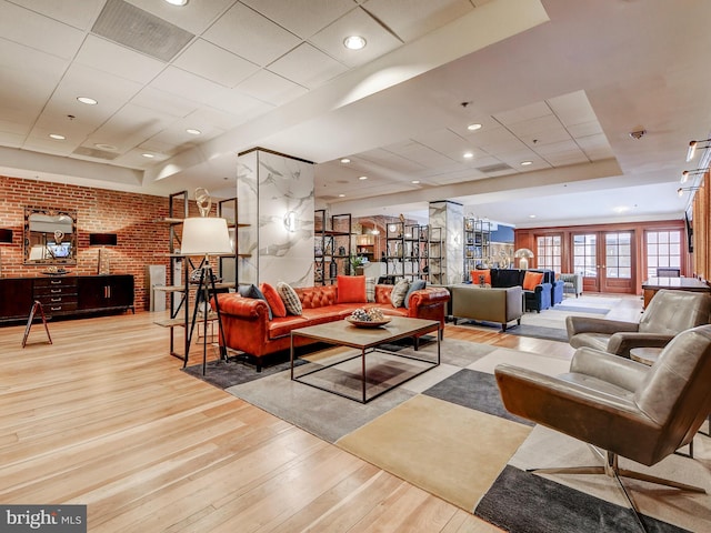 living room featuring light hardwood / wood-style flooring and brick wall