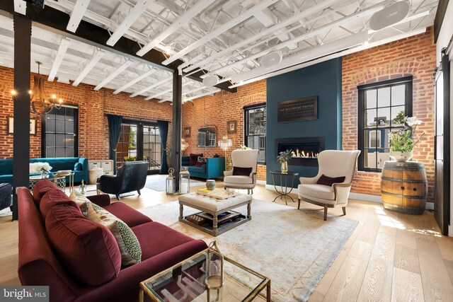 interior space with a high ceiling, brick wall, and light hardwood / wood-style flooring