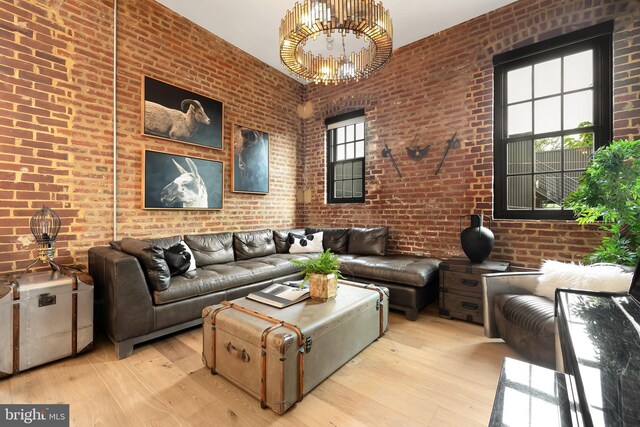 living room featuring brick wall, a high ceiling, and light hardwood / wood-style floors