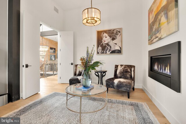 sitting room with a chandelier and light hardwood / wood-style flooring