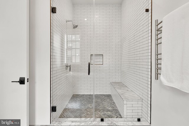 bathroom featuring a shower with door