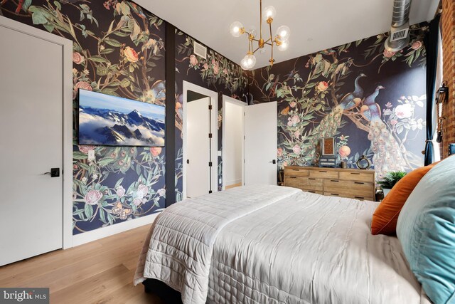 bedroom with a notable chandelier and hardwood / wood-style flooring