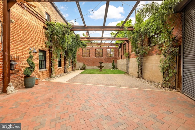 view of patio featuring glass enclosure